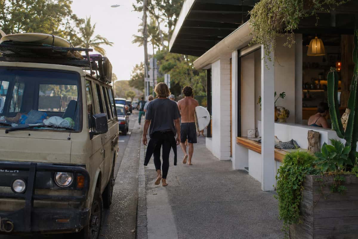 Rue de Byron Bay avec van de surf et café design côte à côte